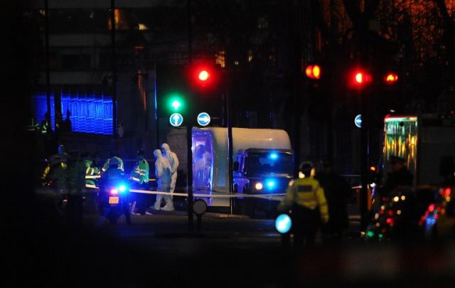 A police Land Rover pulls a car transporter alongside the scene where a grey vehicle crashed into the railings of the Houses of Parliament in Westminster, central London on March 22, 2017, in the aftermath of a terror incident. At least three people were killed and 20 injured in a "terrorist" attack in the heart of London Wednesday when a man mowed down pedestrians on a bridge, then stabbed a police officer outside parliament before being shot dead. Police guarding the iconic House of Commons building shot the man but several people were left with "catastrophic" injuries on Westminster Bridge, a busy traffic junction popular with tourists with views of Big Ben. / AFP PHOTO / DANIEL SORABJI