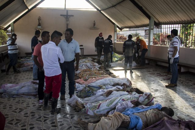 People look for family members among the bodies of victims of mudslides following heavy rains, at the cemetery in Villagarzon, Putumayo department, southern Colombia on April 1, 2017.  Massive mudslides left more than 200 dead and hundreds of injured and disappeared on Saturday in southern Colombia, after heavy rains that have affected the Andean region, especially Peru and Ecuador. / AFP PHOTO / Ernesto Che M Jones