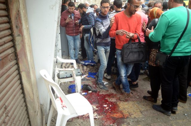 Egyptians look at the scene after suicide bomber in front of a church in Alexandria