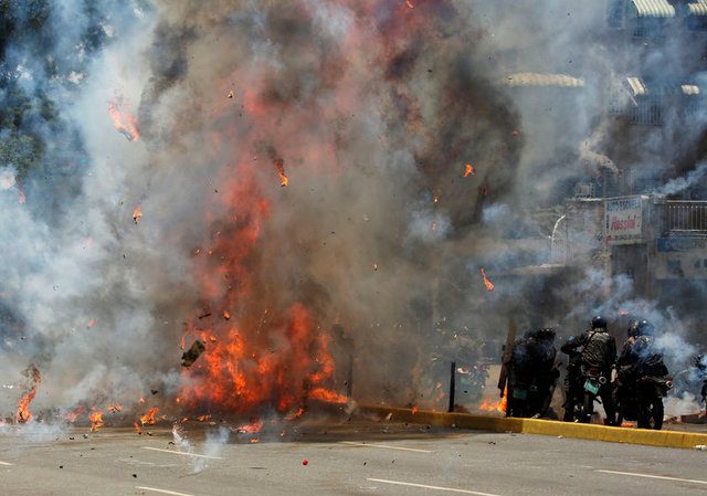 Flames erupt as clashes break out near security forces members (R) while the Constituent Assembly election is being carried out in Caracas, Venezuela, July 30, 2017. REUTERS/Carlos Garcia Rawlins TPX IMAGES OF THE DAY