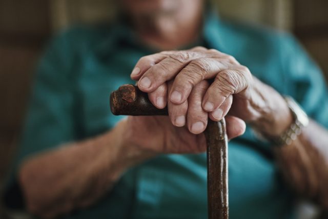 elderly-mans-hands-and-cane-iStock