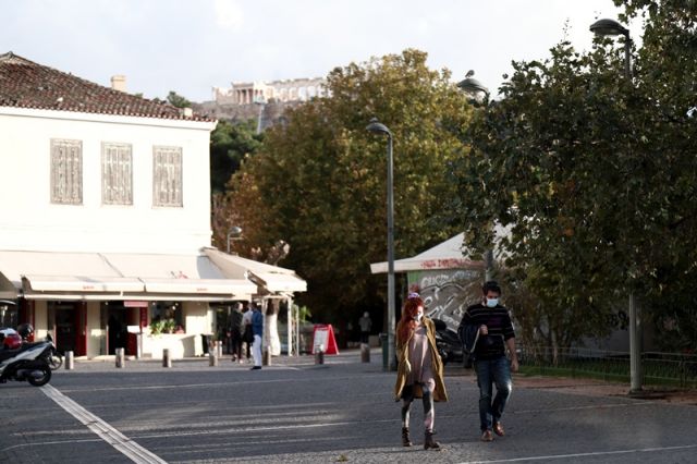 κοπέλα και αγόρι περπατούν με μάσκα στην πλατεία