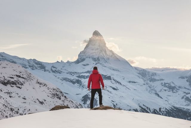 άντρας στέκεται σε χιονισμένο βουνό