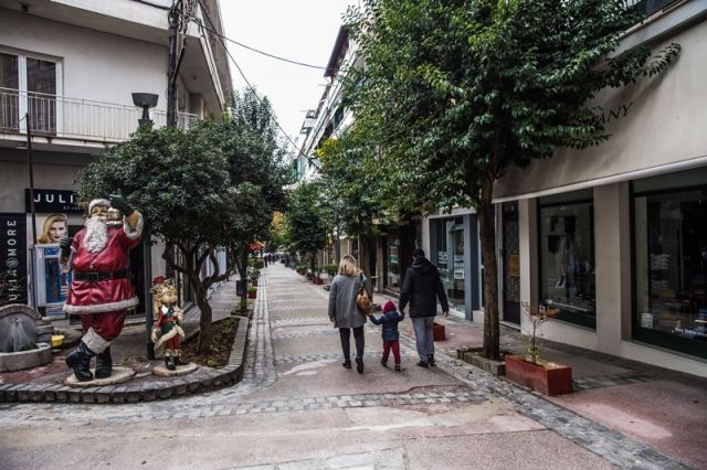 Οικογένεια κάνει βόλτα σε στολισμένο δρόμο