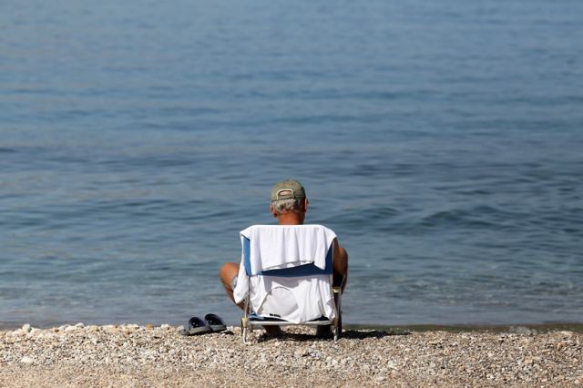 Άνδρας σε καρέκλα παραλία