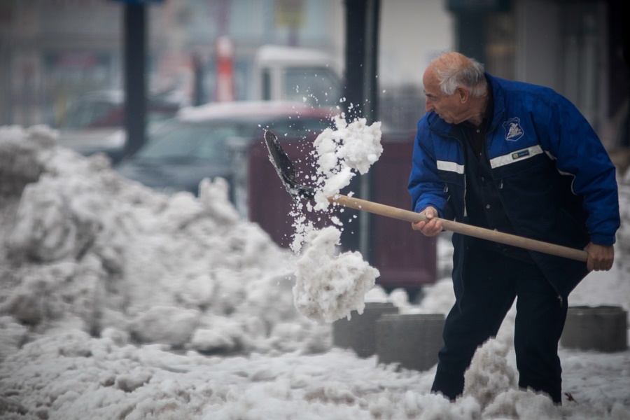 Άνδρας μαζεύει το χιόνι 