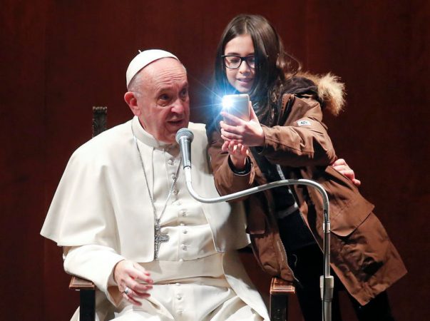 A girl takes a selfie with Pope Francis during a visit to the parish of St. Mary Josefa of the Heart of Jesus in Rome, Italy February 19, 2017. REUTERS/Remo Casilli