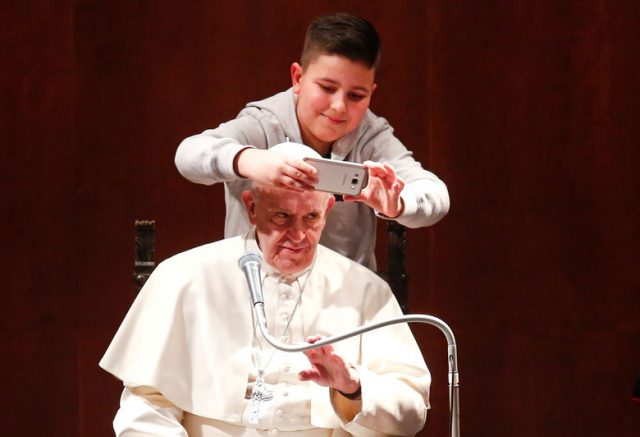 A boy takes selfies with Pope Francis during a visit at the parish of St. Mary Josefa of the Heart of Jesus in Rome February 19, 2017. Picture taken February 19, 2017. REUTERS/Remo Casilli