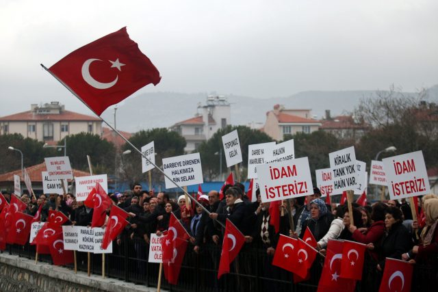Supporters of President Tayyip Erdogan wave Turkish flags during the first hearing of the trial for soldiers accused of attempting to assassinate President Erdogan on the night of the failed last year's July 15 coup, in Mugla, Turkey, February 20, 2017. REUTERS/Kenan Gurbuz