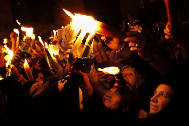 Christian pilgrims hold candles at the Church of the Holy Sepulchre, traditionally believed to be the burial site of Jesus Christ, during the ceremony of the Holy Fire in Jerusalem's Old City, Saturday, April 14, 2012. During the annual ceremony, top clerics enter the Edicule, the small chamber marking the site of Jesus' tomb. They emerge after  to reveal candles lit with "holy fire" ? said to be miraculously lit as a message to the faithful from heaven. The details of the flame's source are a closely guarded secret. (AP Photo/Bernat Armangue)