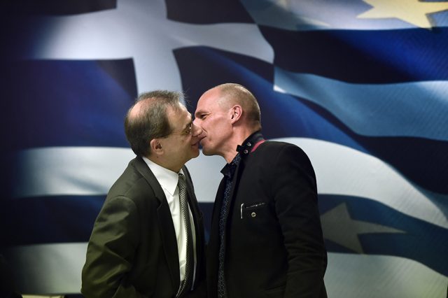 L'ex ministro greco delle Finanze Yanis Varoufakis bacia Gikas Hardouvelis, ministro delle Finanze prima di lui. La fotografia è stata scattata il 28 gennaio ad Atene (ARIS MESSINIS/AFP/Getty Images)