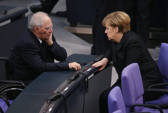 BERLIN, GERMANY - DECEMBER 17:  German Chancellor Angela Merkel (R) and Finance Minister Wolfgang Schaeuble chat during a vote at the Bundestag over her third term as chancellor during ceremonies in which the new German government will be sworn in on December 17, 2013 in Berlin, Germany. The new government is a coalition between the German Christian Democrats (CDU), the Bavarian Christian Democrats (CSU) and German Social Democrats (SPD) following federal elections held in September.  (Photo by Sean Gallup/Getty Images)