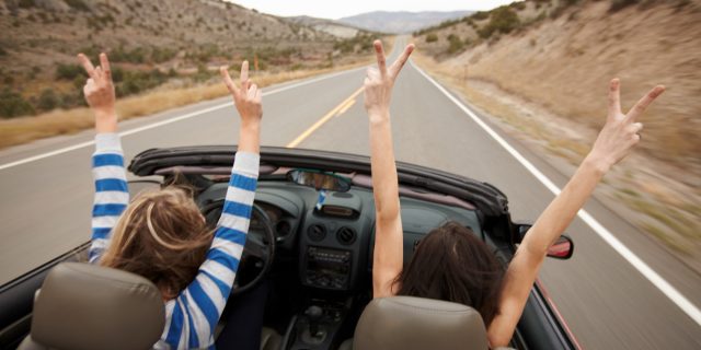 Hands up, while driving a convertible.