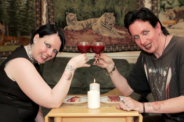 ***EXCLUSIVE*** SUFFOLK, UNITED KINGDOM - JUNE 17: Lia Benninghoff and Aro Draven sit opposite each other with glasses of blood, smiling and toasting to their engagement on June 17, 2013 in Suffolk, England. LIA Benninghoff and Aro Draven have an unconventional relationship - they drink each other's blood. The couple, from Haverhill, Suffolk, believe they are vampires and feed from each other once a week. Lia, 20, and Aro, 38, plan to tie the knot in a vampire style wedding on Halloween. PHOTOGRAPH BY Matt Writtle / Barcroft Media UK Office, London. T +44 845 370 2233 W www.barcroftmedia.com USA Office, New York City. T +1 212 796 2458 W www.barcroftusa.com Indian Office, Delhi. T +91 11 4053 2429 W www.barcroftindia.com *** Local Caption *** 01479815