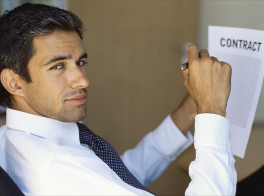 Side profile of a businessman signing a contract