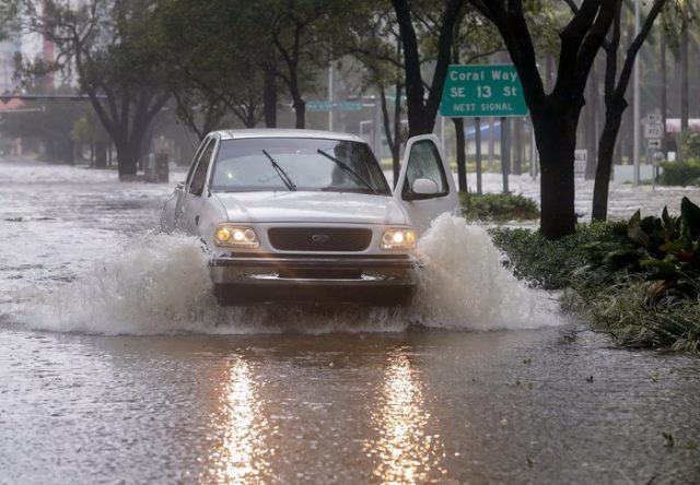 epa06197197 A pickup truck drives through the storm surge flood waters along Brickell Avenue after the full effects of Hurricane Irma struck in Miami, Florida, USA, 10 September 2017. Many areas are under mandatory evacuation orders as Irma Florida. EPA/ERIK S. LESSER