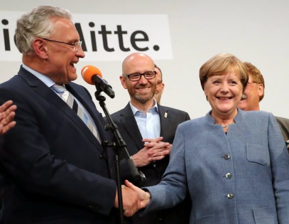 epa06225025 German Chancellor Angela Merkel (R) of the Christian Democratic Union (CDU) shakes hands with Joachim Herrmann (L) Bavarian Minister of the Interior late in the evening at the CDU election event in Berlin, Germany, 24 September 2017. According to federal election commissioner more than 61 million people were eligible to vote in the elections for a new federal parliament, the Bundestag, in Germany. EPA/CARSTEN KOALL