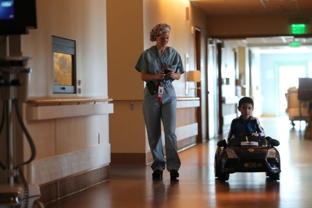 Doctor Daniela Carvalho controls Jonathan Jauregui, 7, remotely as Rady Children's Hospital unveil a program that uses remote control cars, donated by the local police officers charity, to take young patients to the operating room, in San Diego, California, U.S. September 19, 2017.     REUTERS/Mike Blake