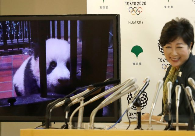 A panda cub named Xiang Xiang, born from mother panda Shin Shin at Tokyo's Ueno Zoological Gardens on June 12, 2017, is shown on a screen next to Tokyo Governor Yuriko Koike during a news conference to announce the name at Tokyo Metropolitan Government Building in Tokyo, Japan September 25, 2017. REUTERS/Kim Kyung-Hoon     TPX IMAGES OF THE DAY