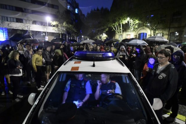 Catalan police sit in their patrol car as people gather outside a polling station in Barcelona, on October 1, 2017, to prevent the police to seal it off in a referendum on independence for Catalonia banned by Madrid. Madrid has vowed to stop the referendum from going ahead, closing polling stations, seizing millions of ballot papers, detaining key organisers and shutting down websites promoting the vote.  / AFP PHOTO / JOSE JORDAN / The erroneous mention[s] appearing in the metadata of this photo by JOSE JORDAN has been modified in AFP systems in the following manner: [Barcelona] instead of [Figueras]. Please immediately remove the erroneous mention[s] from all your online services and delete it (them) from your servers. If you have been authorized by AFP to distribute it (them) to third parties, please ensure that the same actions are carried out by them. Failure to promptly comply with these instructions will entail liability on your part for any continued or post notification usage. Therefore we thank you very much for all your attention and prompt action. We are sorry for the inconvenience this notification may cause and remain at your disposal for any further information you may require.