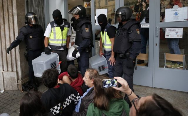 Spanish police seize ballot boxes in a polling station in Barcelona, on October 1, 2017, on the day of a referendum on independence for Catalonia banned by Madrid. More than 5.3 million Catalans are called today to vote in a referendum on independence, surrounded by uncertainty over the intention of Spanish institutions to prevent this plebiscite banned by justice. / AFP PHOTO / PAU BARRENA