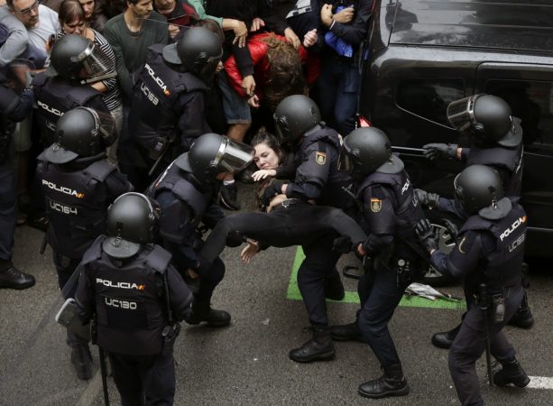 epaselect epa06237308 Spanish National riot policemen evict a young woman during clashes between the people gathered outside the Ramon Llull school and police forces during the '1-O Referendum' in Barcelona, Catalonia, on 01 October 2017. National Police officers and Civil guards have been deployed in Barcelona to prevent the people from entering to the polling centers and vote in the Catalan independence referendum, that has been banned by the Spanish Constitutional Court. The police action has provocked clashes between pro-independence people and the police forces.  EPA/Alberto Estevez  Dostawca: PAP/EPA.