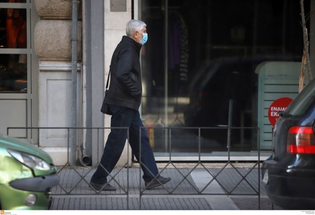 κύριος με μάσκα περπατά στο δρόμο