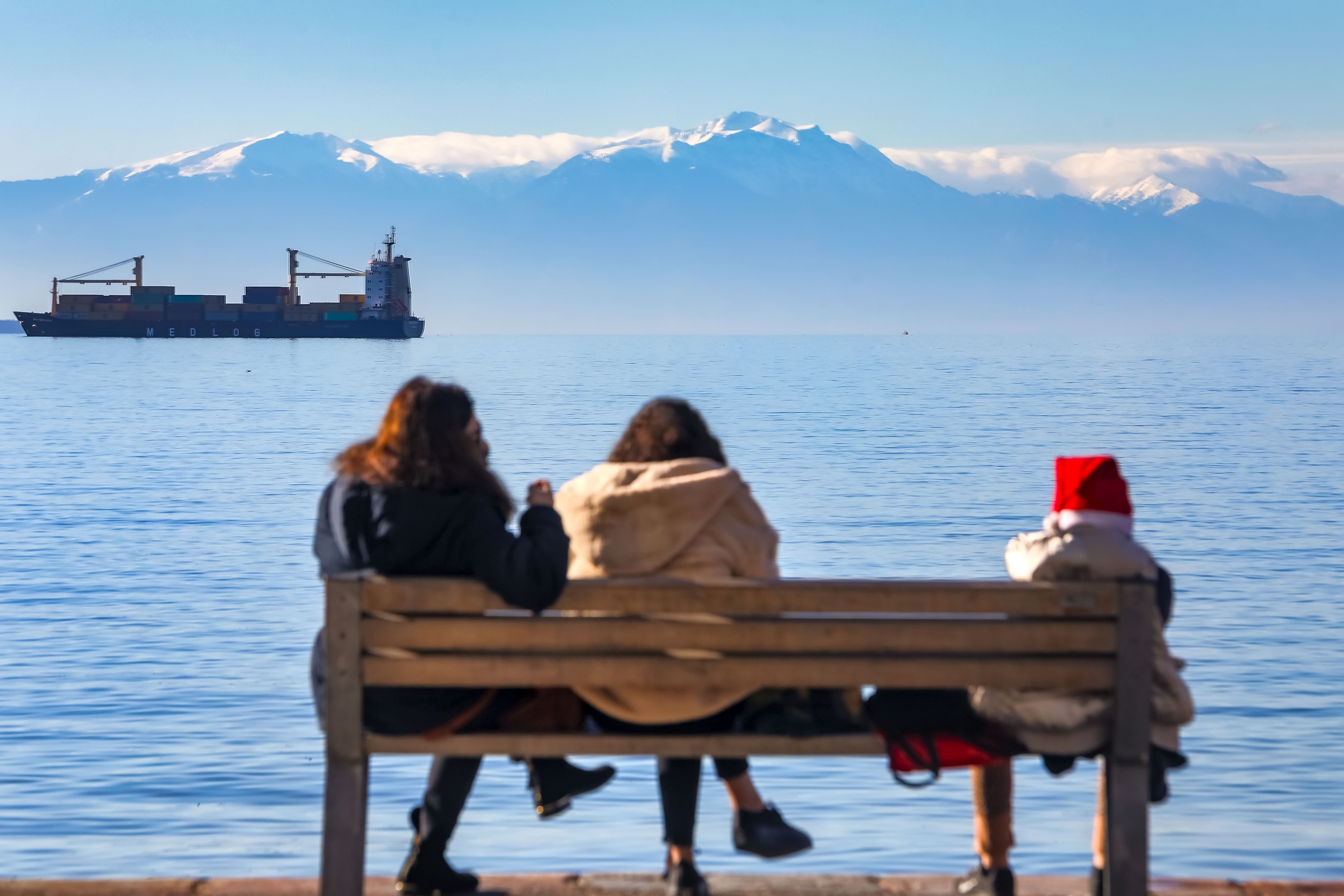 Άνθρωποι κάθονται σε παγκάκι στη Θεσσαλονίκη