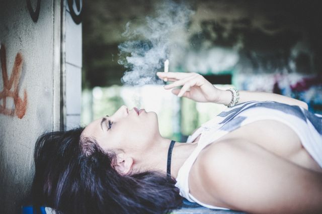 Κοπέλα καπνίζει ξαπλωμένη