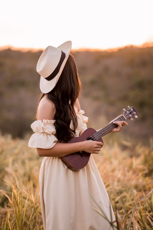 Κοπέλα με καπέλο παίζει κιθάρα