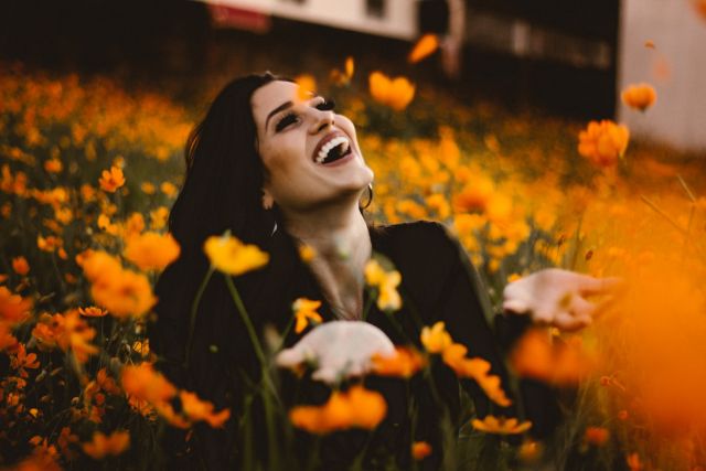 κορίτσι γελάει μέσα σε λουλούδια