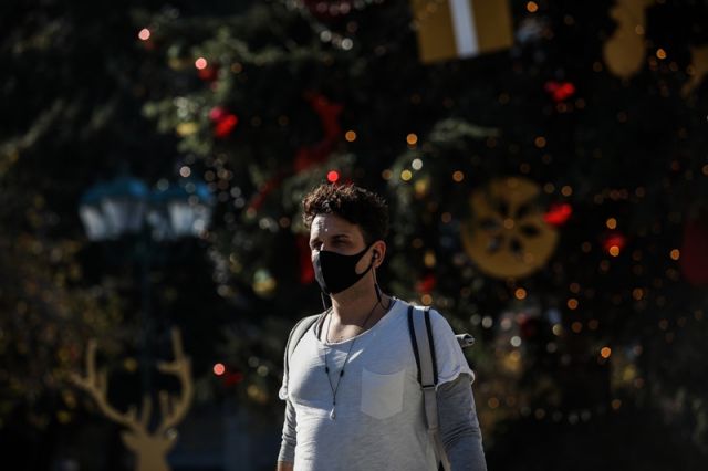 αγόρι με μάσκα σε χριστουγεννιάτικο φόντο