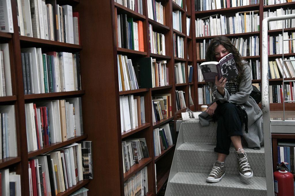 Βιβλιοπωλείο Κοπέλα διαβάζει βιβλίο στις σκάλες 