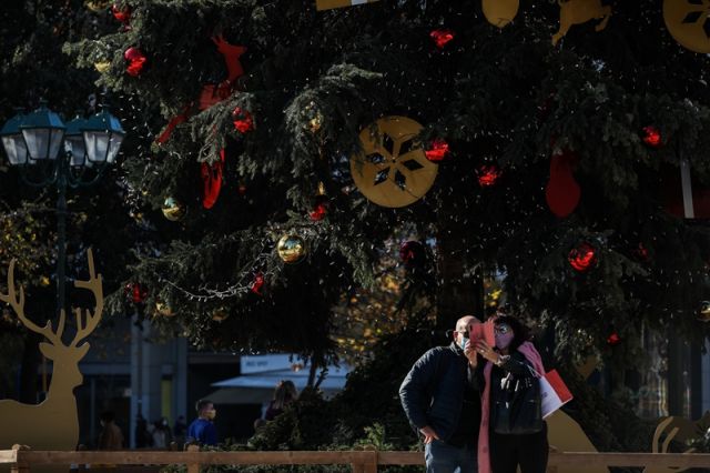 ζευγάρι φωτογραφίζεται στο χριστουγεννιάτικο δέντρο