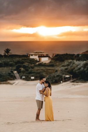 άνδρας φιλάει κοπέλα με κίτρινο φουστάνι στο ηλιοβασίλεμα 