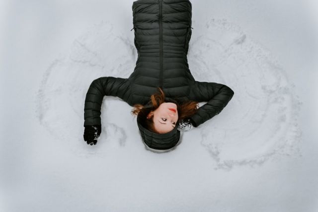 Κοπέλα ξαπλωμένη στο χιόνι