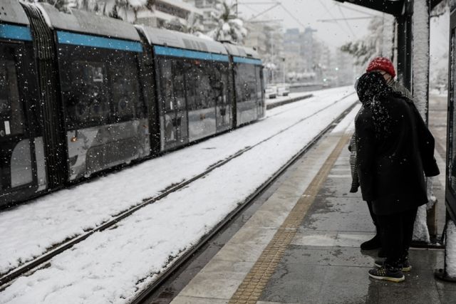 Κόσμος περιμένει στο τραμ ενώ χιονίζει 